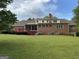 View of brick home, large deck, lawn and mature trees from expansive backyard at 2451 Old Salem Se Cir, Conyers, GA 30013
