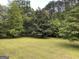 The backyard features mature trees and a meticulously maintained lawn at 2451 Old Salem Se Cir, Conyers, GA 30013