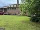 Well-maintained backyard with a large lawn, mature tree, and access to a partially hidden garage at 2451 Old Salem Se Cir, Conyers, GA 30013