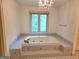 Luxurious bathroom featuring a chandelier over a tiled tub at 2451 Old Salem Se Cir, Conyers, GA 30013