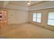 Large main bedroom with neutral carpet, tray ceiling, and natural light at 2451 Old Salem Se Cir, Conyers, GA 30013