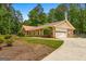 Exterior showcasing the attached two-car garage and mature trees around the property at 200 Whitney Way, Fayetteville, GA 30214