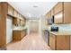 Kitchen with vintage wallpaper, wood cabinets, and stainless-steel appliances at 200 Whitney Way, Fayetteville, GA 30214