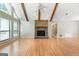 Living room showcasing vaulted ceilings, exposed beams, brick fireplace and large window at 200 Whitney Way, Fayetteville, GA 30214