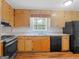 Traditional kitchen with wood cabinets and black appliances at 2609 Lake Harbin Rd, Morrow, GA 30260