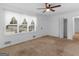 Bright living room featuring neutral carpeting, a ceiling fan, and a large window at 2609 Lake Harbin Rd, Morrow, GA 30260