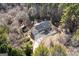 Overhead view of large house featuring attached garage, ample parking, and sprawling tree-lined property at 3133 Callie Still Rd., Lawrenceville, GA 30045
