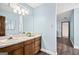 A blue toned bathroom features a white sink with wood cabinets, a marble countertop, and wood trim at 3133 Callie Still Rd., Lawrenceville, GA 30045