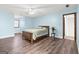 Bright primary bedroom with a ceiling fan, hardwood floors, a window, and an ensuite bathroom at 3133 Callie Still Rd., Lawrenceville, GA 30045