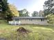 Home backyard with green grass, deck, and mature trees surrounding the property at 5219 Maple Valley Sw Rd, Mableton, GA 30126