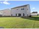 A well-maintained backyard featuring lush green grass and a neutral-colored house with a sliding glass door at 838 Maduro Way, Mcdonough, GA 30253