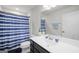 Well-lit bathroom featuring a vanity with a sink and a blue striped shower curtain at 838 Maduro Way, Mcdonough, GA 30253