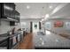 Open kitchen layout with stainless steel appliances, granite countertops, and a dining area nearby at 838 Maduro Way, Mcdonough, GA 30253