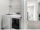 A laundry room with new washer and dryer appliances, plus wire rack shelving at 838 Maduro Way, Mcdonough, GA 30253