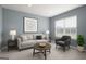A cozy living room featuring a neutral sofa, chair, and artwork against pale blue walls at 838 Maduro Way, Mcdonough, GA 30253