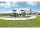 A playground with green slides and equipment next to a barn and a green grass area at 838 Maduro Way, Mcdonough, GA 30253