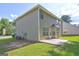 Back of home featuring a small concrete patio, green lawn, and pale green siding at 325 Espana St, South Fulton, GA 30349