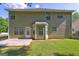 Back of home featuring a small concrete patio, green lawn, and pale green siding at 325 Espana St, South Fulton, GA 30349