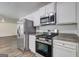 Well-equipped kitchen featuring stainless steel appliances and white cabinetry for a sleek look at 325 Espana St, South Fulton, GA 30349