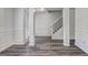 Open-concept living area featuring elegant wall trim, wood-look floors, and access to the staircase at 325 Espana St, South Fulton, GA 30349
