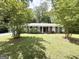 Traditional home with lush lawn, mature trees, and welcoming front facade at 4313 Executive Dr, Stone Mountain, GA 30083
