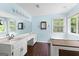 Bathroom featuring a tub, vanity, sinks, and blue walls at 224 Claridge Curv, Peachtree City, GA 30269