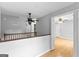 Upstairs hallway with hardwood floors and view into another room at 224 Claridge Curv, Peachtree City, GA 30269