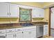 This modern kitchen offers sleek white cabinetry, stainless steel dishwasher, and contrasting countertops at 224 Claridge Curv, Peachtree City, GA 30269