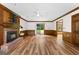 Bright living room with wood-look floors, ceiling fan, and brick fireplace featuring decorative wood mantle at 224 Claridge Curv, Peachtree City, GA 30269