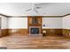 Light-filled living room features wood-look flooring, a brick fireplace, and classic wood trim at 224 Claridge Curv, Peachtree City, GA 30269