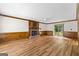Spacious living room features a brick fireplace, wood-look floors, and sliding glass door to backyard at 224 Claridge Curv, Peachtree City, GA 30269