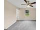 Bedroom featuring neutral walls, new carpet, a ceiling fan, and a view through the window at 5669 Blackberry Row, Ellenwood, GA 30294