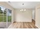 Bright dining room featuring wood-look floors, modern lighting, and sliding glass doors to the backyard at 5669 Blackberry Row, Ellenwood, GA 30294