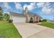 Single-story home boasts stone accents, a neutral exterior, attached garage, and a well-manicured lawn at 5669 Blackberry Row, Ellenwood, GA 30294