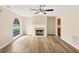 Spacious living room featuring a fireplace, large window, ceiling fan, and beautiful wood-look flooring at 5669 Blackberry Row, Ellenwood, GA 30294