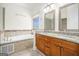 Bright bathroom with a soaking tub and double vanity with granite countertops and undermount sinks at 225 S South Shore Ter, Fayetteville, GA 30214