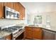 Close-up of the kitchen with stainless steel appliances, granite countertops, and wood cabinets at 225 S South Shore Ter, Fayetteville, GA 30214