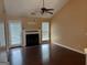 Open living room with a fireplace, fan, and hardwood floors with lots of natural light at 95 Revere Turn Drive, Fairburn, GA 30213
