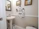 Cozy half bath features a pedestal sink, decorative mirror, and framed artwork at 112 Kirton Turn, Peachtree City, GA 30269