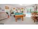 Bright game room featuring a pool table, comfortable seating, and natural light with backyard access and pool views at 112 Kirton Turn, Peachtree City, GA 30269