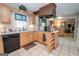 Functional kitchen featuring tile flooring, natural wood cabinetry, and a cooktop on the island at 112 Kirton Turn, Peachtree City, GA 30269