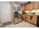 Traditional kitchen with wood cabinetry, stainless steel refrigerator, and tile flooring at 112 Kirton Turn, Peachtree City, GA 30269