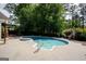 Backyard swimming pool featuring a concrete surround and shaded by mature trees creating a private retreat at 112 Kirton Turn, Peachtree City, GA 30269