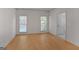 Spacious bedroom with two windows, light-colored wood floors, and an open doorway at 1155 Graystone Xing, Alpharetta, GA 30005