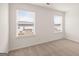 Neutral-toned bedroom featuring two bright windows with views of other homes, along with light-colored walls and carpet at 1804 Quaker St, Hampton, GA 30228