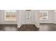 Inviting entryway with a front door, dark wood-look floors, natural light from two side windows at 1804 Quaker St, Hampton, GA 30228