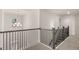 Upstairs hallway features modern railing, neutral paint, and a stylish light fixture, complemented by plush gray carpeting at 1804 Quaker St, Hampton, GA 30228