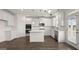 Bright kitchen featuring white cabinets, an island, stainless steel appliances, and hardwood floors at 1804 Quaker St, Hampton, GA 30228