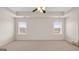 Large main bedroom with two windows, neutral carpet and tiered ceiling at 1804 Quaker St, Hampton, GA 30228