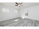 This is a bright bedroom featuring wood-look floors, a ceiling fan and three windows letting in lots of natural light at 458 Prescott Way, Villa Rica, GA 30180